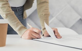 mujer firmando documentación técnica sobre edificio