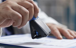 manos sellando una licencia concedida para apertura de negocio